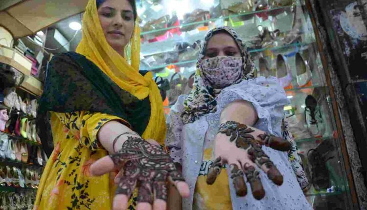 Ahead of Eid festival, girls show their hands adorned with Mendhi in Jammu.